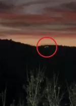 Fotograma nocturno: luces sobre una sierra boscosa, señaladas con un círculo rojo.